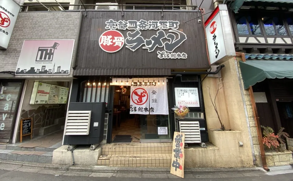 Top Hat Building entrance with the TH sign, just left of a tonkotsu ramen shop
